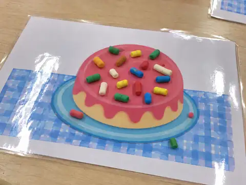 Pastel con chispas de plastilina en el tapete plastificado
